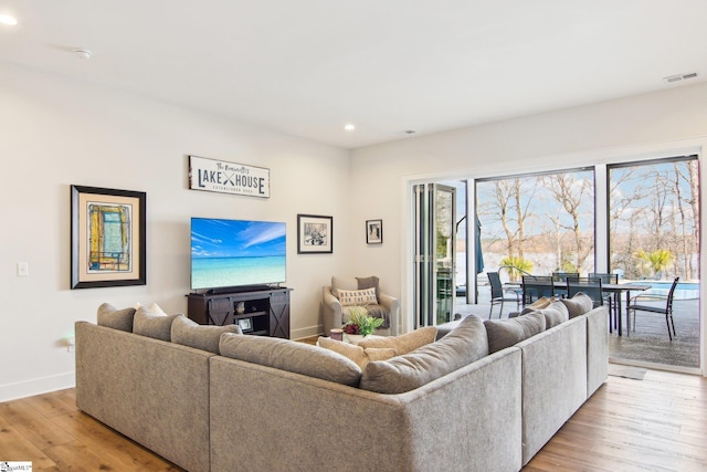 living room featuring recessed lighting, visible vents, light wood-style flooring, and baseboards