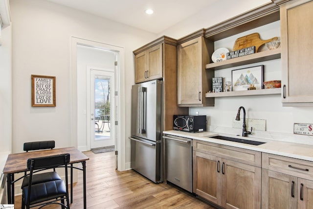 kitchen featuring a sink, recessed lighting, light wood-style floors, stainless steel appliances, and open shelves