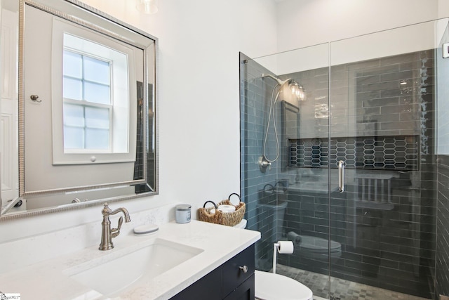 full bathroom featuring vanity, a shower stall, and toilet