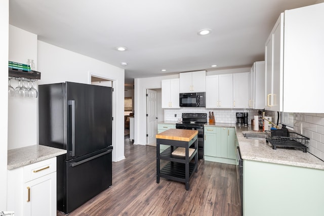 kitchen featuring dark wood finished floors, backsplash, white cabinets, and black appliances