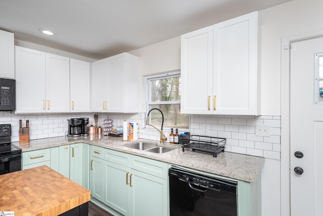 kitchen with a sink, decorative backsplash, black appliances, and white cabinets