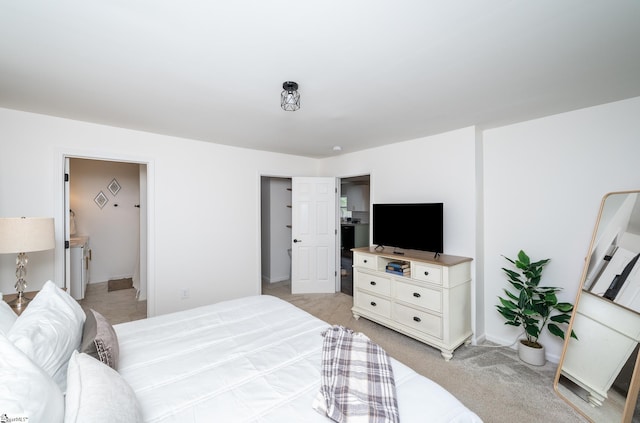 bedroom featuring light carpet, washer / dryer, and baseboards