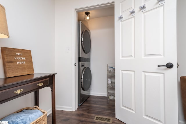 laundry area with visible vents, baseboards, laundry area, dark wood-style floors, and stacked washer / drying machine