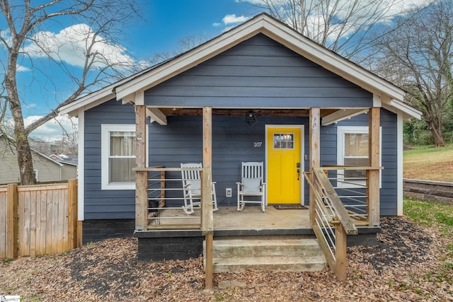 bungalow-style home featuring fence and covered porch