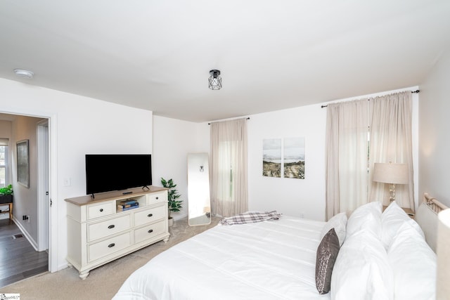 bedroom featuring baseboards and light colored carpet