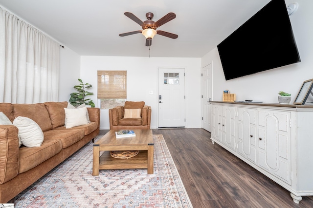 living room featuring wood finished floors, baseboards, and ceiling fan