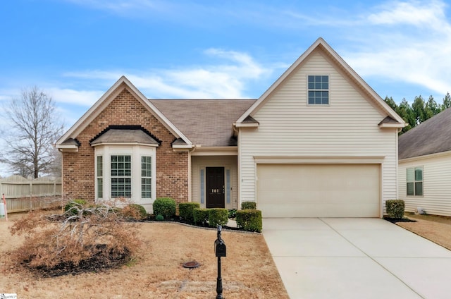 view of front of home with concrete driveway, fence, brick siding, and roof with shingles