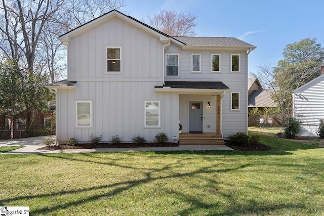 modern farmhouse style home featuring roof with shingles, board and batten siding, a front yard, and fence