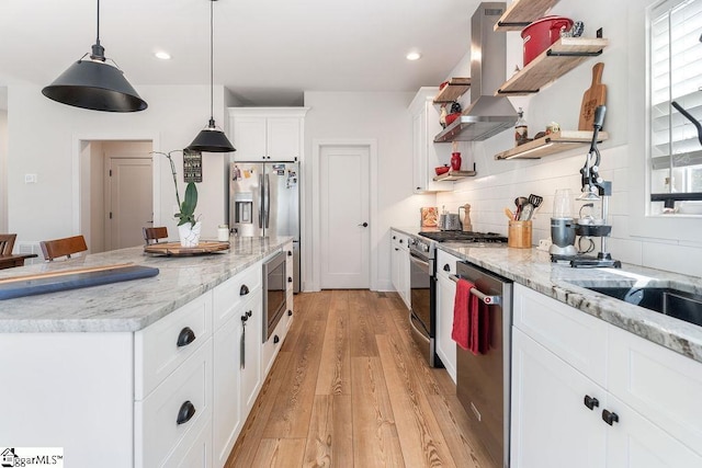 kitchen featuring open shelves, stainless steel appliances, light wood-style floors, wall chimney exhaust hood, and tasteful backsplash