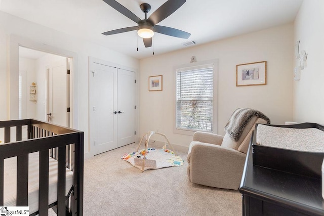 bedroom featuring visible vents, baseboards, ceiling fan, light colored carpet, and a closet