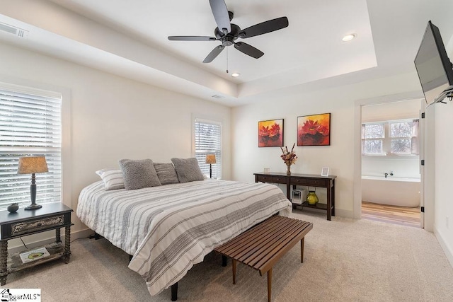 bedroom featuring a raised ceiling, recessed lighting, visible vents, and light carpet