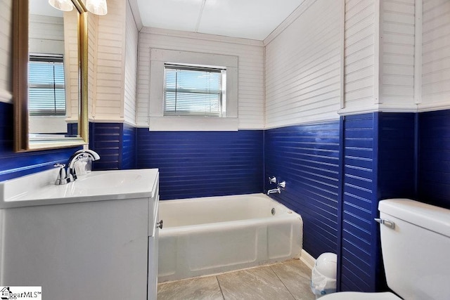 full bath featuring toilet, a tub, and vanity