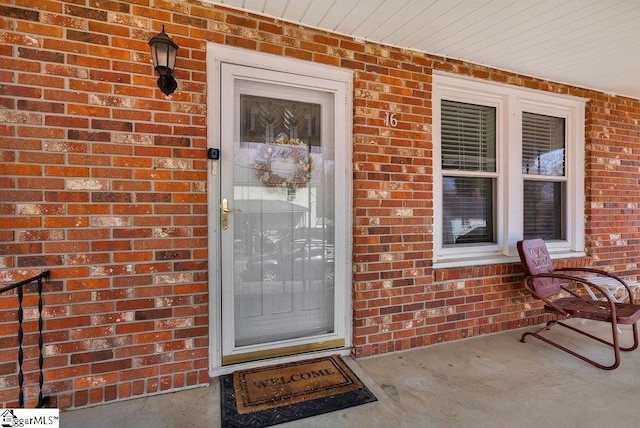 doorway to property featuring brick siding