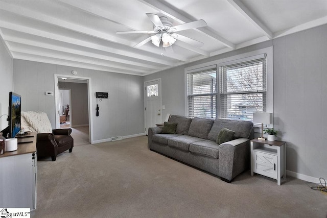 living area featuring beamed ceiling, carpet floors, baseboards, and a ceiling fan