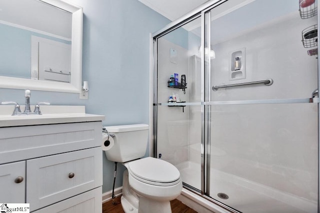 full bathroom featuring vanity, wood finished floors, baseboards, a shower stall, and toilet