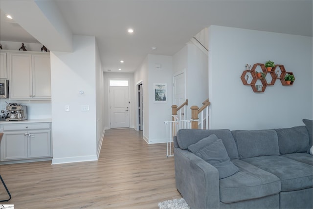 living area with recessed lighting, baseboards, and light wood-style floors