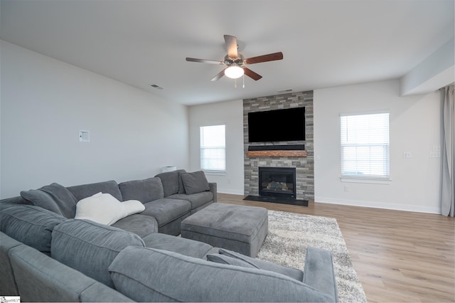 living room featuring visible vents, baseboards, light wood-type flooring, and ceiling fan