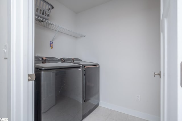 laundry area featuring laundry area, light tile patterned floors, separate washer and dryer, and baseboards