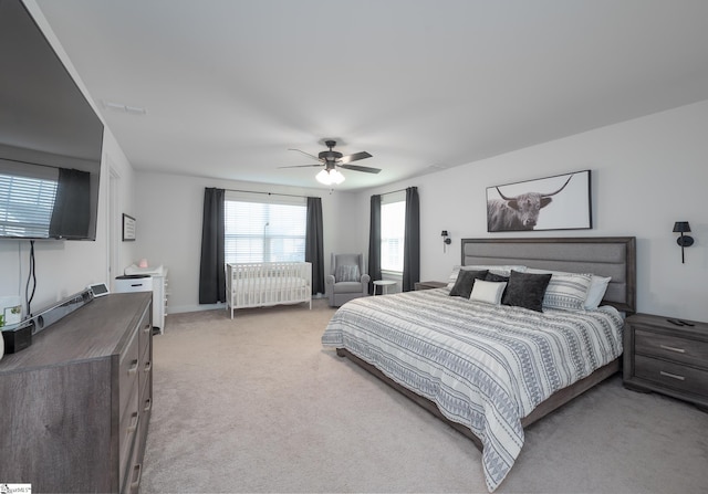 bedroom featuring radiator heating unit, a ceiling fan, and light carpet