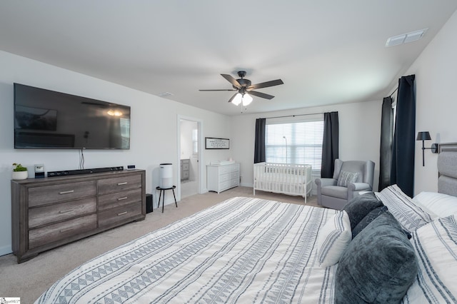 bedroom featuring radiator heating unit, a ceiling fan, visible vents, and light carpet