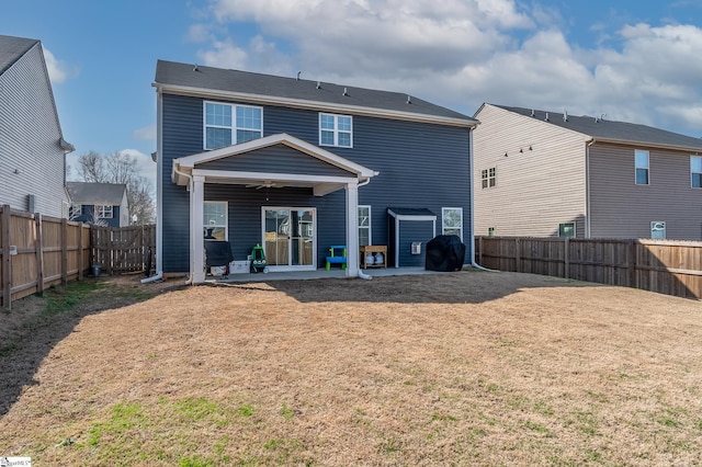 rear view of house featuring a ceiling fan, a patio, a fenced backyard, and a lawn