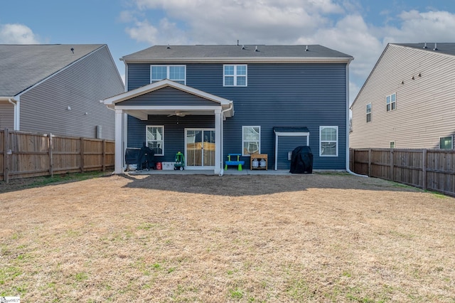 rear view of property with a yard, a patio, a fenced backyard, and a ceiling fan