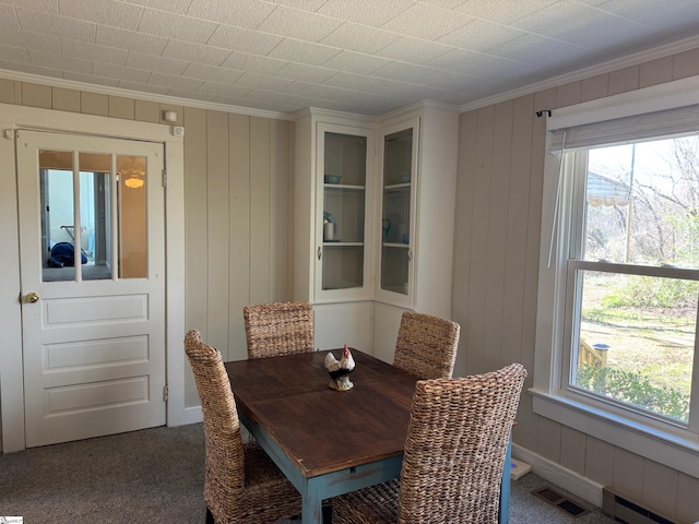 dining room with a wealth of natural light, visible vents, baseboard heating, and ornamental molding