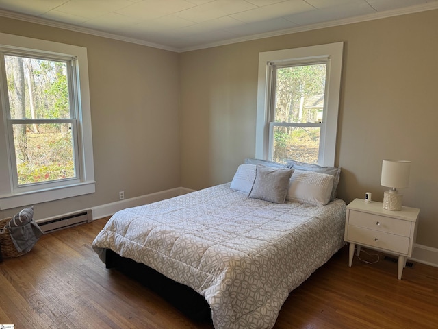 bedroom featuring baseboard heating, multiple windows, crown molding, and wood finished floors