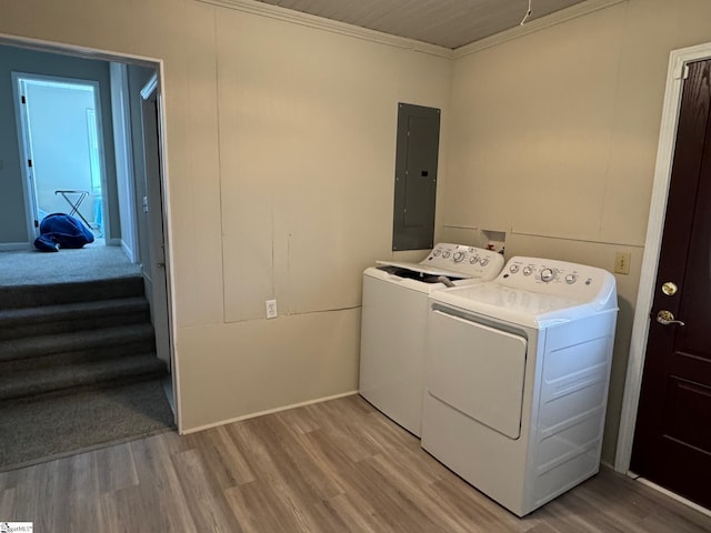 laundry room featuring ornamental molding, electric panel, laundry area, light wood-style floors, and separate washer and dryer