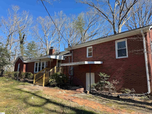 view of side of property with brick siding and a chimney