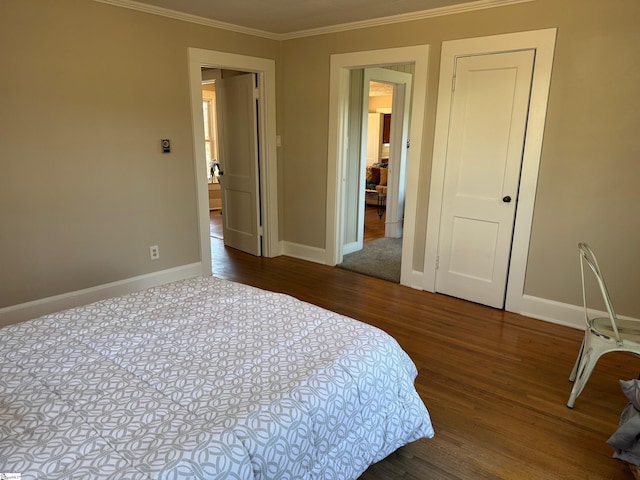 bedroom featuring baseboards, wood finished floors, and ornamental molding