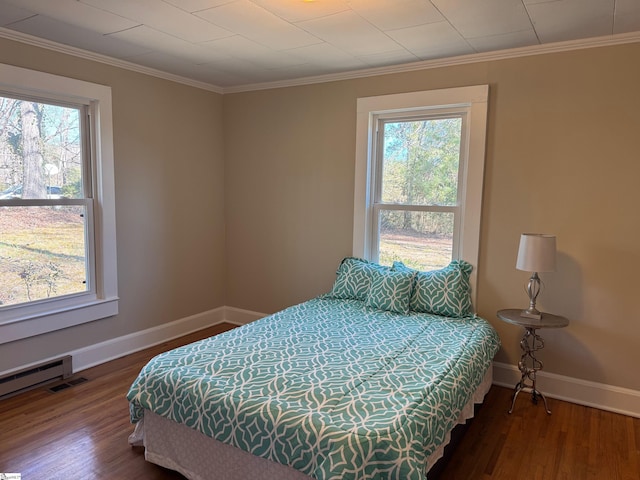 bedroom with visible vents, multiple windows, and wood finished floors