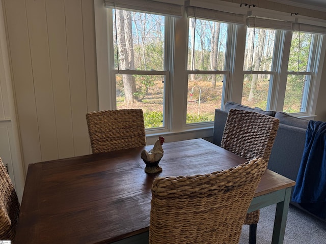 dining space featuring wood walls