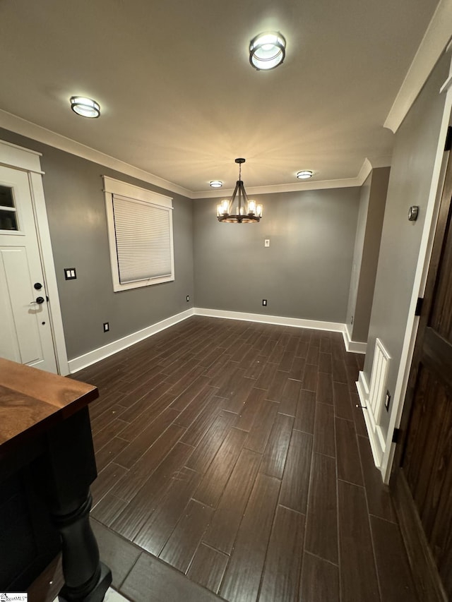 unfurnished dining area with ornamental molding, baseboards, a chandelier, and wood tiled floor