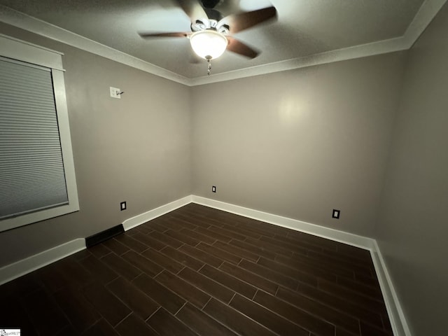 spare room featuring baseboards, dark wood-style floors, a ceiling fan, and crown molding