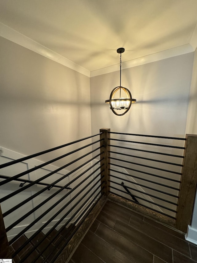 interior space featuring an inviting chandelier, wood finished floors, and ornamental molding