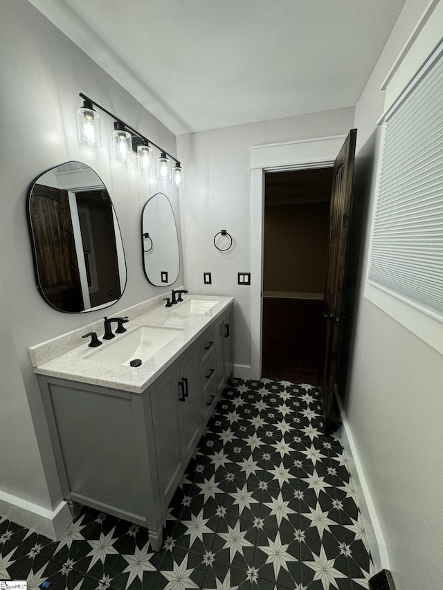 bathroom featuring tile patterned floors, double vanity, baseboards, and a sink