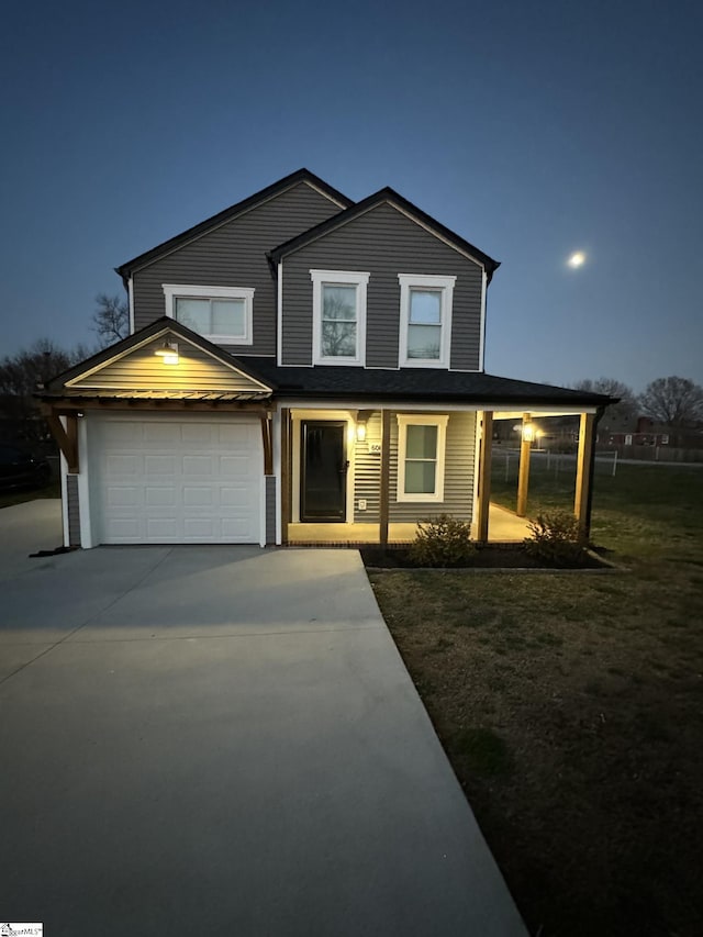 view of front of property featuring driveway, a front yard, and a garage