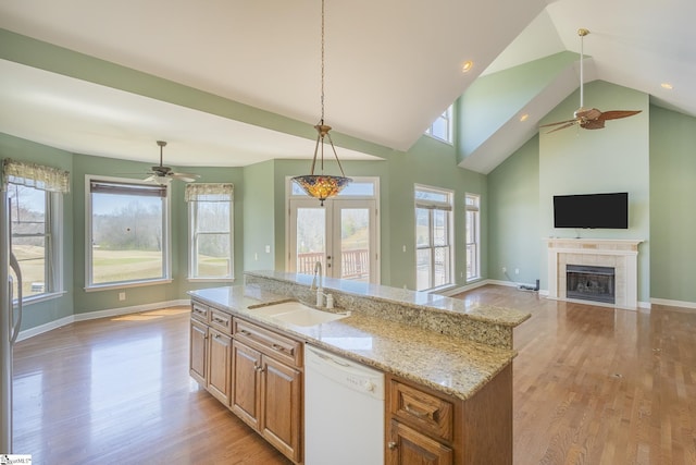 kitchen with a sink, dishwasher, a ceiling fan, and light wood finished floors