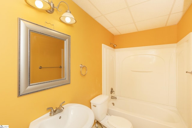 full bathroom with a drop ceiling, toilet, bathtub / shower combination, and a sink