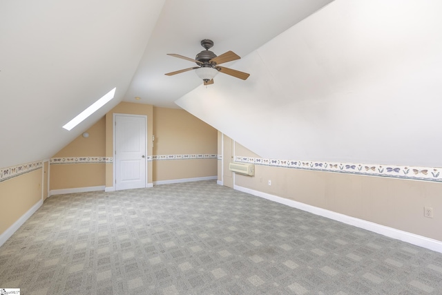 bonus room with baseboards, lofted ceiling with skylight, ceiling fan, and carpet flooring