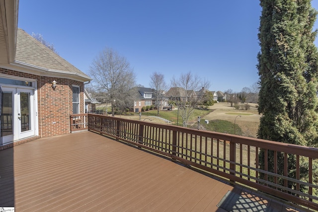 wooden deck with french doors, a residential view, and a yard