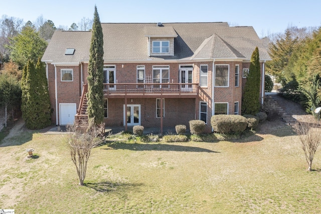 rear view of house featuring a deck, french doors, a yard, brick siding, and stairs