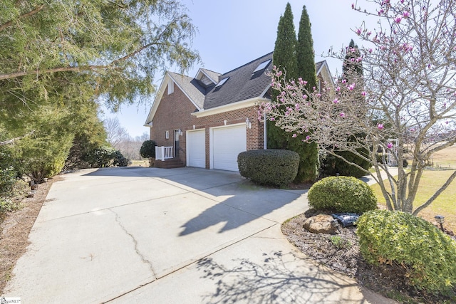 view of property exterior featuring brick siding and concrete driveway