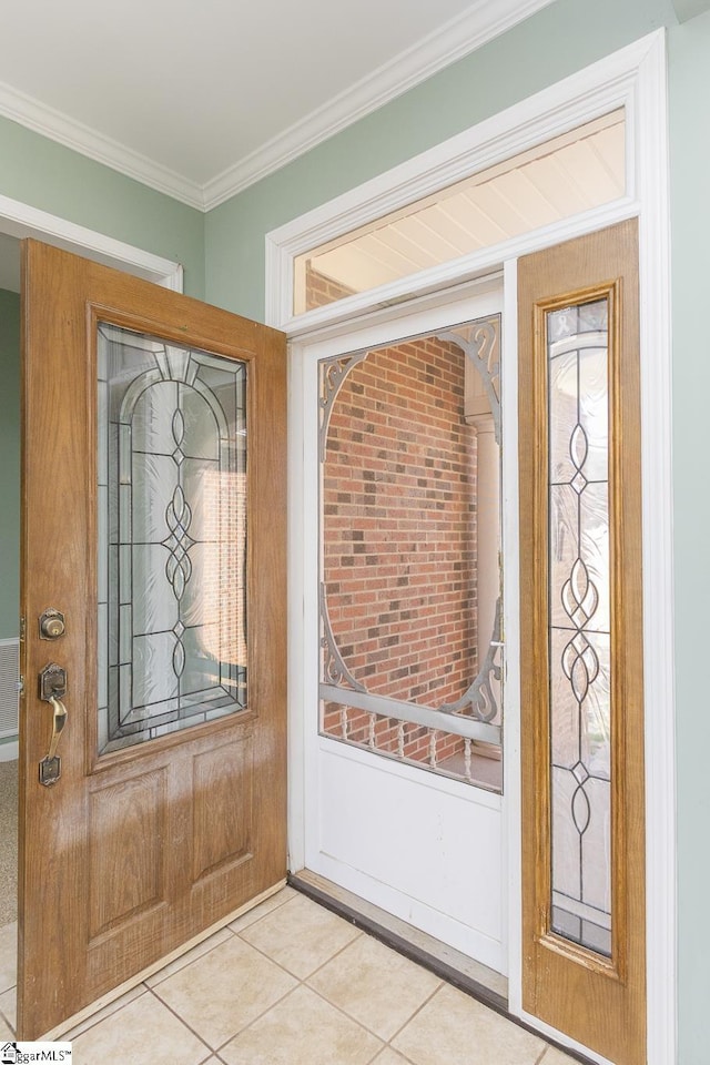 entrance foyer featuring light tile patterned floors and ornamental molding