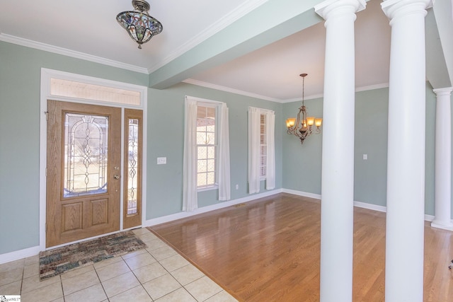 entrance foyer featuring a chandelier, light wood finished floors, baseboards, and ornamental molding