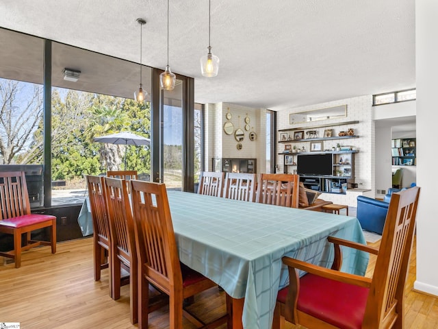 145 Dickson Rd, Campobello, SC 29322 - dining room featuring a textured ceiling, a brick fireplace, and wood finished floors