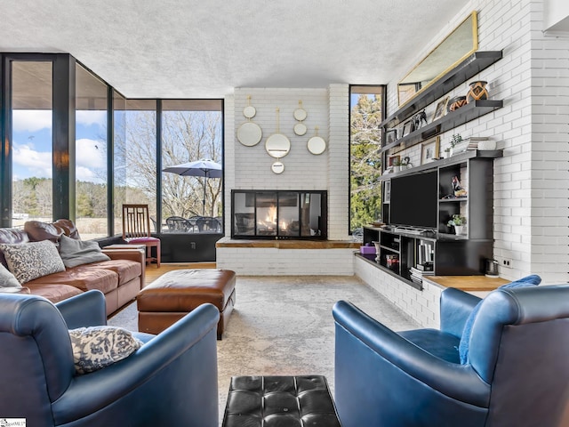 145 Dickson Rd, Campobello, SC 29322 - living area featuring floor to ceiling windows, a fireplace, brick wall, and a textured ceiling