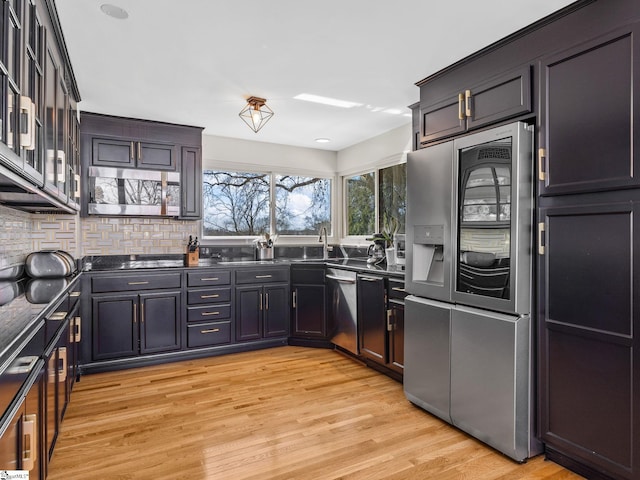 145 Dickson Rd, Campobello, SC 29322 - kitchen featuring dark countertops, light wood-style flooring, backsplash, and appliances with stainless steel finishes