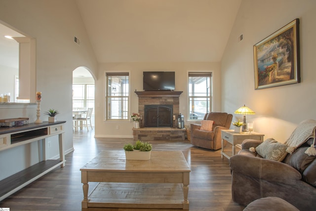 living room with visible vents, arched walkways, dark wood-type flooring, and high vaulted ceiling